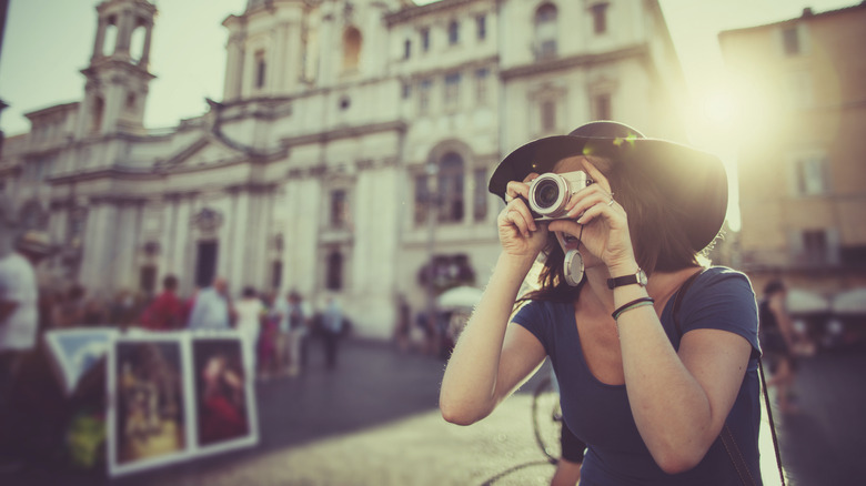 woman in hat taking picture