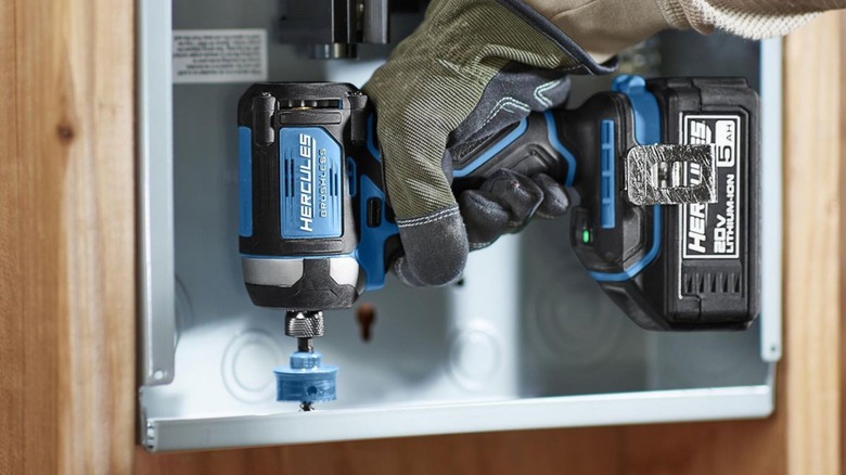 Person using an impact driver to create a hole