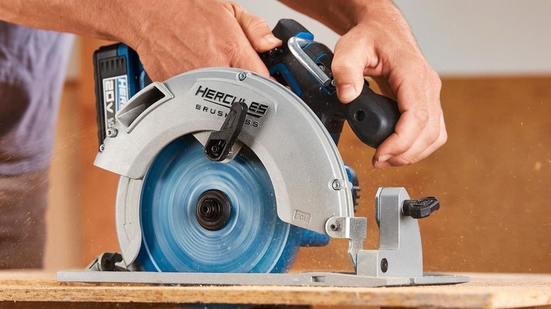 Person using a circular saw to cut a piece of wood