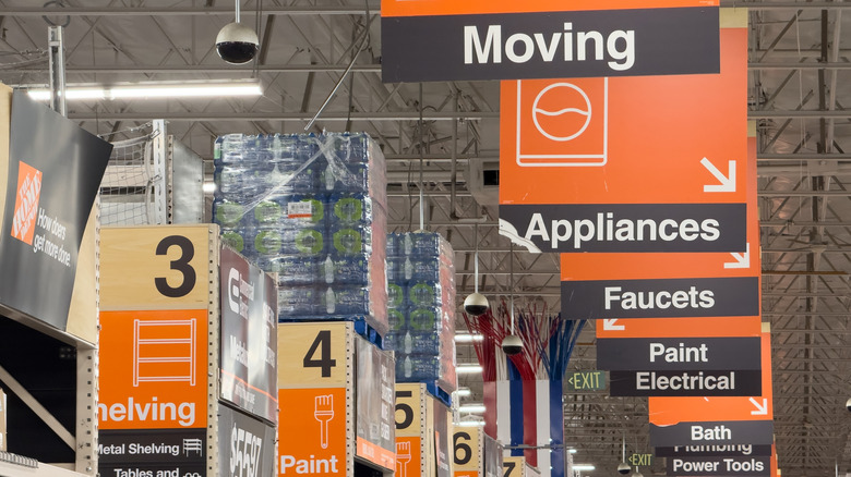 Interior of a Home Depot store with large signs indicating different departments