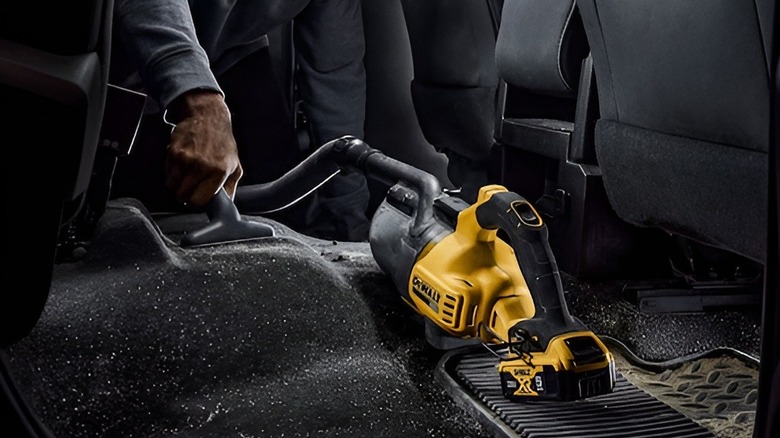 Vacuuming car floor with DeWalt vacuum