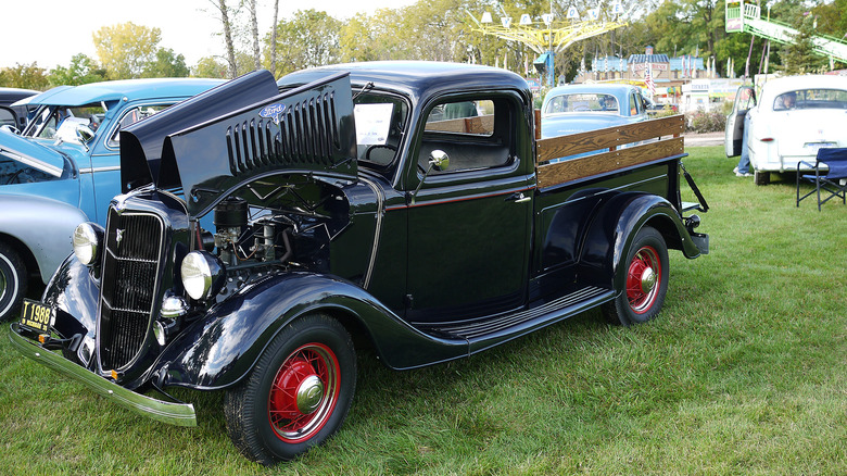 A black 1935 Ford Model 50 Pickup at a car show