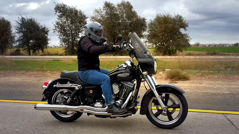 A rider with a helmet riding a Dyna Switchback down a road at speed in fall