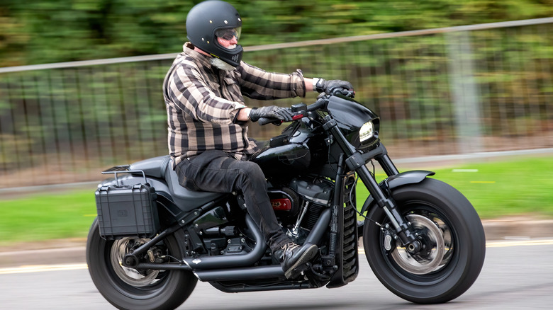 A man in a checked shirt riding a 2018 Harley Fat Bob