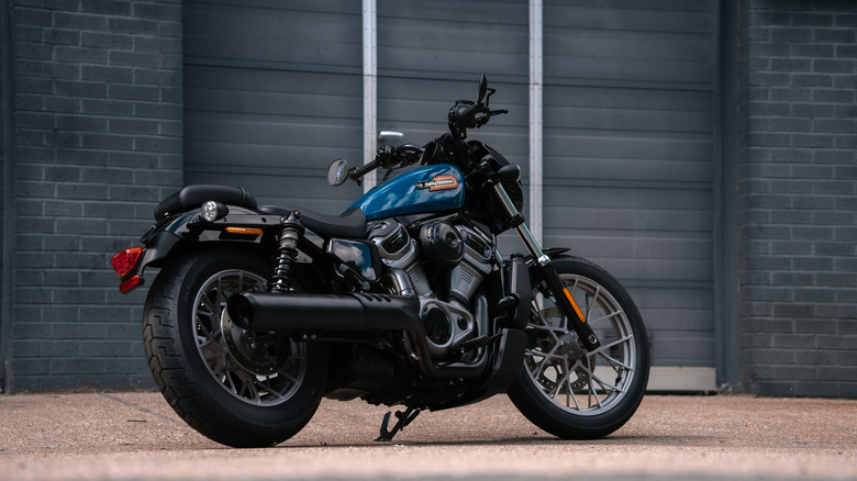 A blue chopper-style Harley Davidson Nightster bike parked outside a shop in the UK