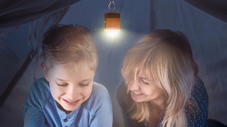 mom and child with flashlight in tent