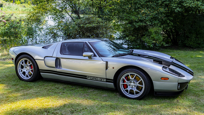 Front 3/4 view of silver 2005 Ford GT parked on grass at car show.