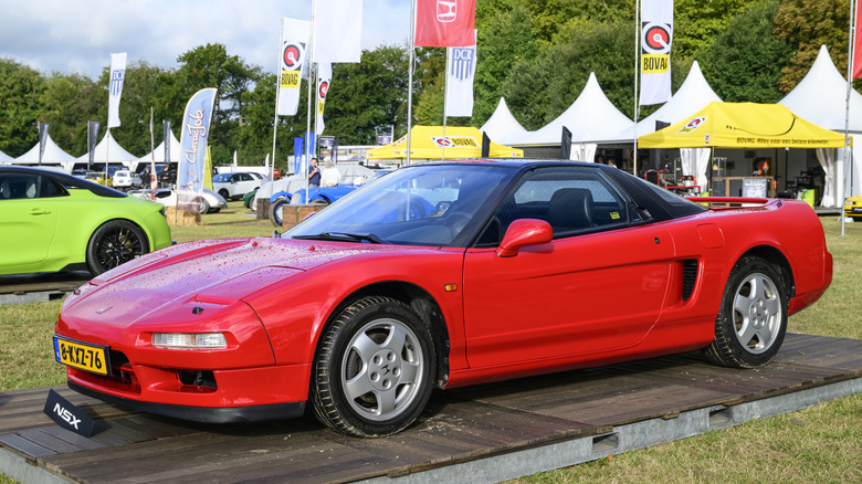 Front three-quarter view of red Acura NSX on display at car show.