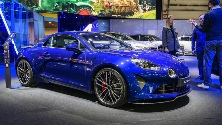 Front three-quarter view of blue Renault Alpine A110 on display at auto show.