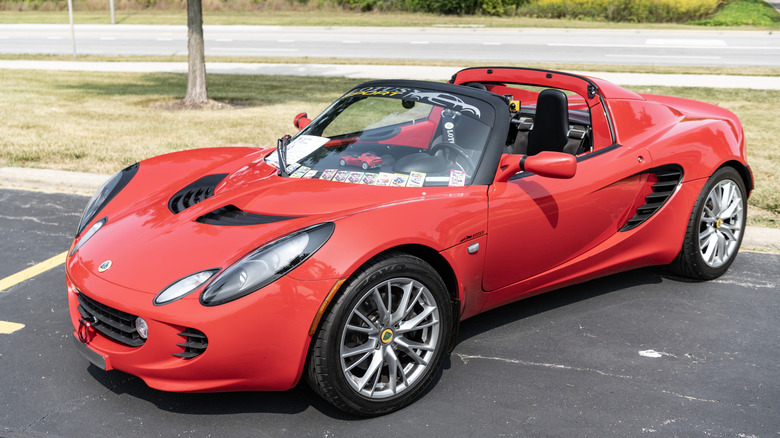 Front three-quarter view of red Lotus Elise parked on display at car show.