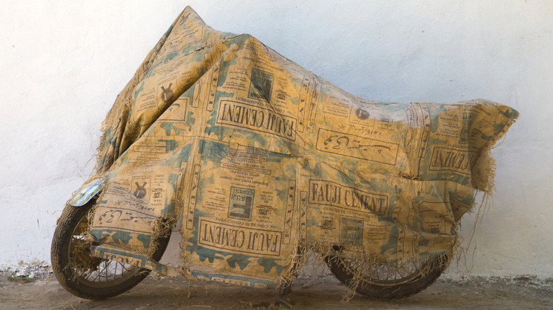Motorcycle covered with dilapidated cement bags