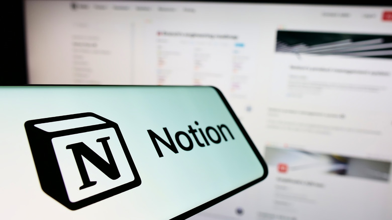 Notion app on phone in front of monitor