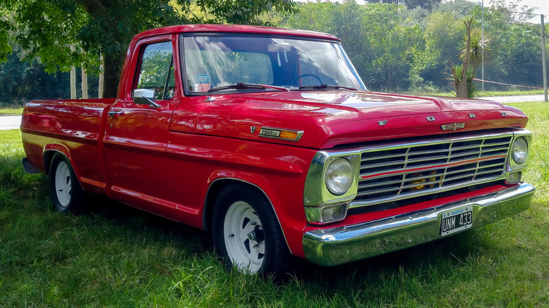 A 1960 Ford F-100 parked in front of a tree