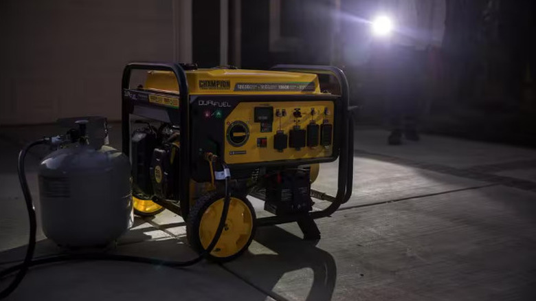 A portable generator attached to a propane tank in a dark work area