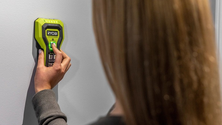 homeowner using a Ryobi stud detector