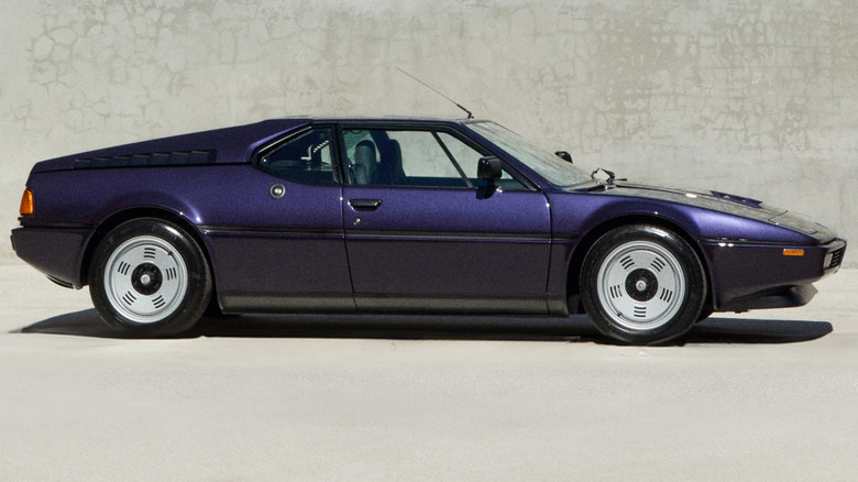 BMW M1 side view with a grey wall in the background