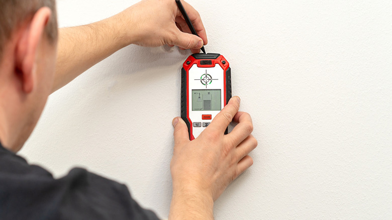 man using stud finder