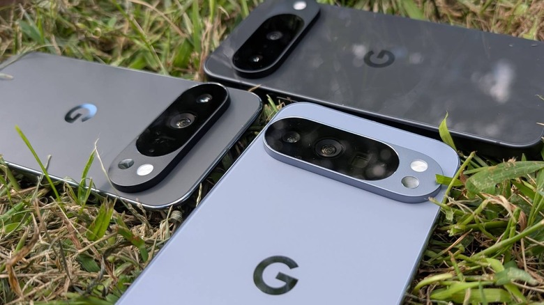 Three Google Pixel devices face-down on grass