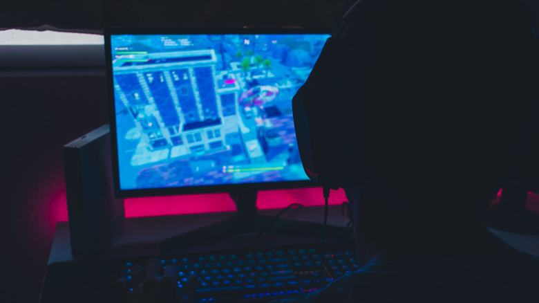 Person playing Fortnite dark room