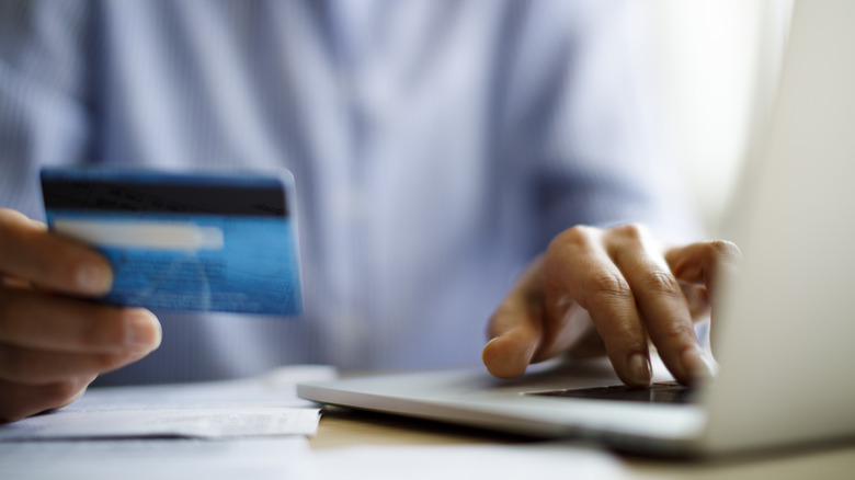 Person using laptop with credit card