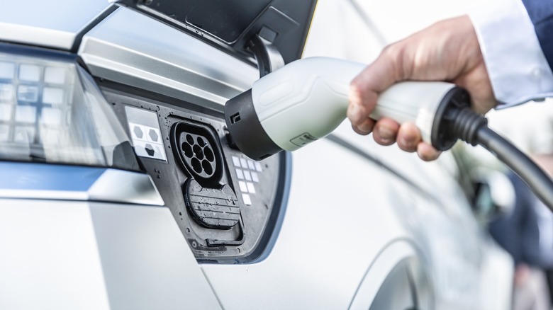 Person charging electric vehicle