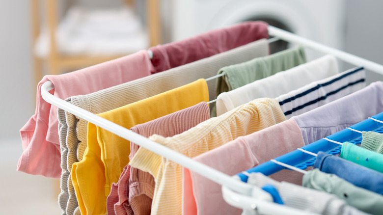 Colorful laundry spread out over a drying rack