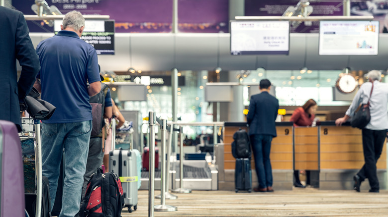 Passengers lined up at an airport kiosk