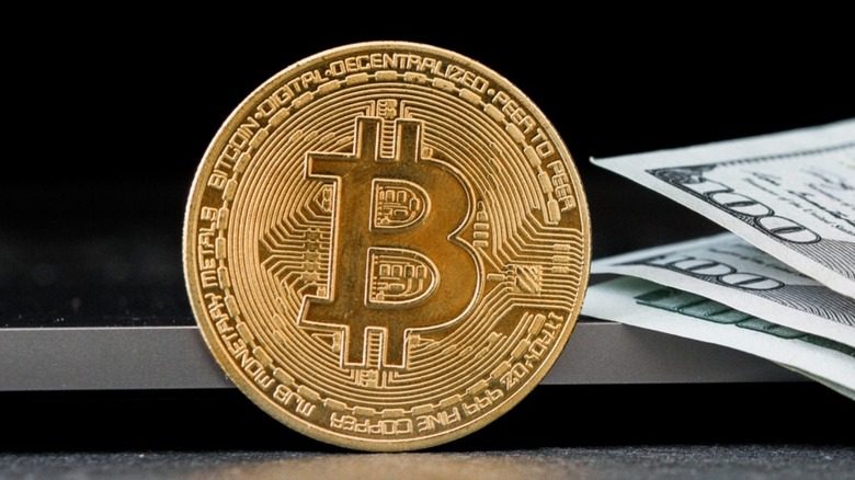 Bitcoin coin near paper money