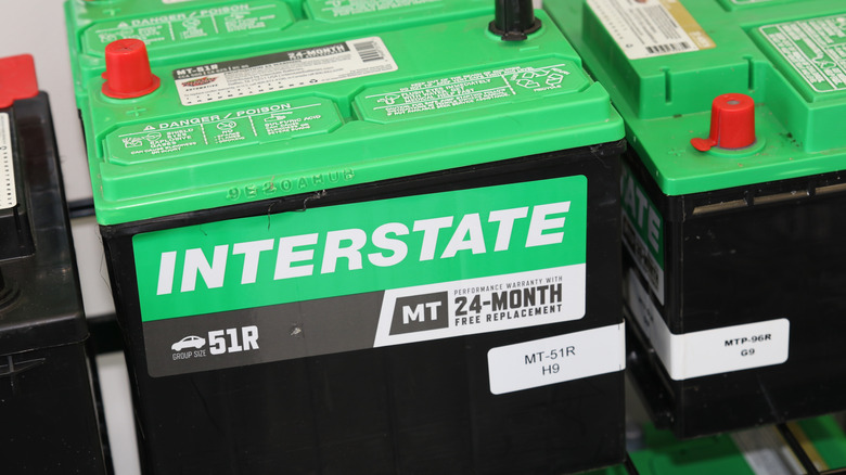 A large black and green Interstate battery with a 24-month warranty sticker displayed