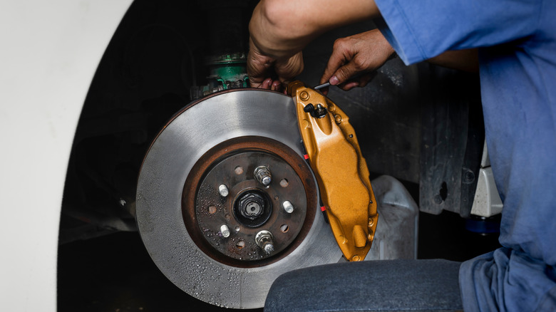 A man servicing a vehicles brakes