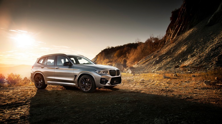 BMW on cliffside terrain against sunset