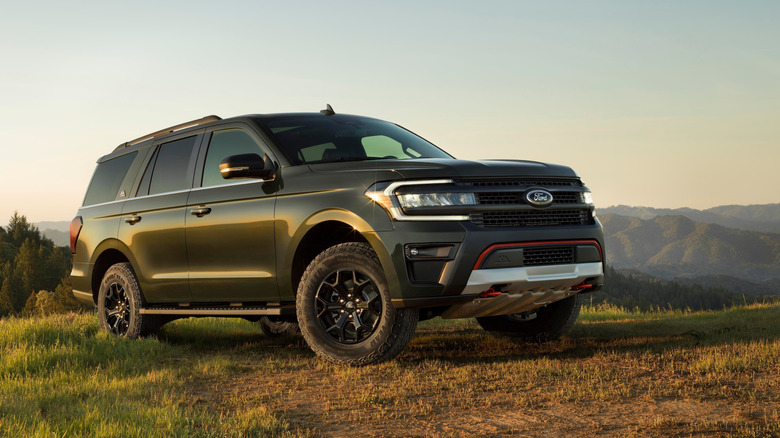 Front 3/4 view of green Ford Expedition Timberline parked in grassy hills.