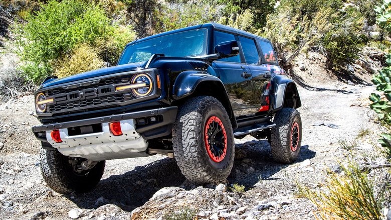 Front view of black Ford Bronco Raptor on off-road trail.