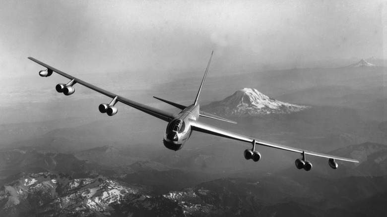 Early model B-52 Stratofortress in flight over mountains