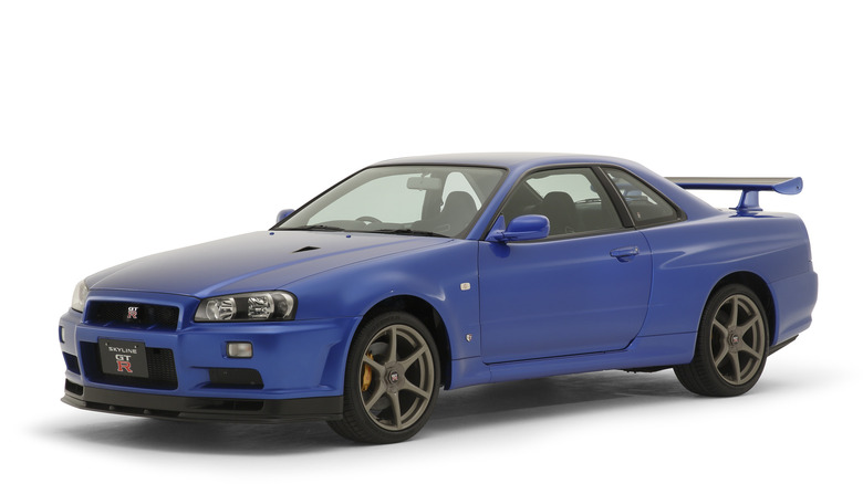 2000 Nissan Skyline GT-R V-Spec II in Bay Side Blue on white background, front-left 3/4 view