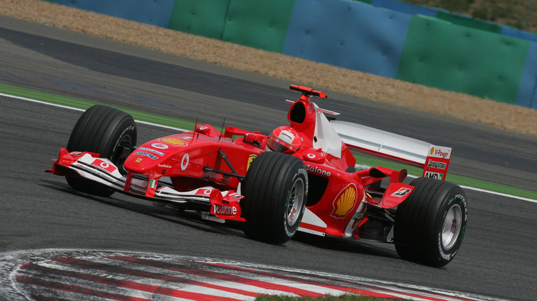 Ferrari F2004 racing around circuit, front-left view