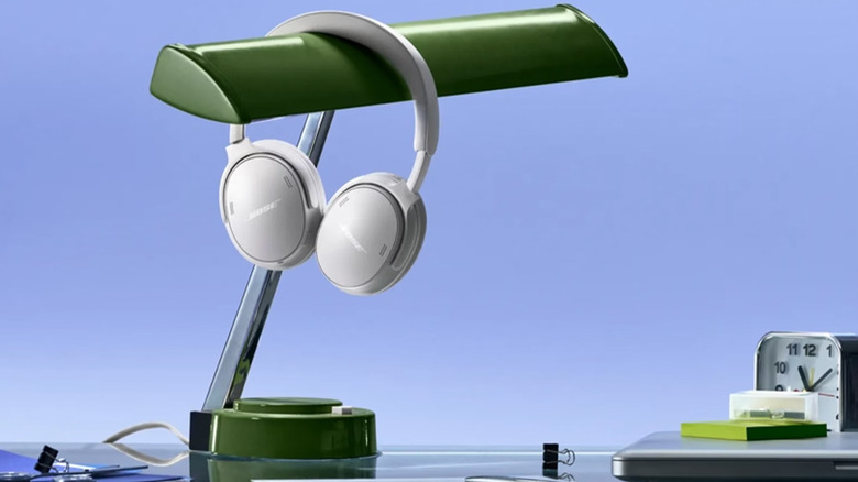 A white pair of Bose QuietComfort 2nd Gen headphones on a lamp.