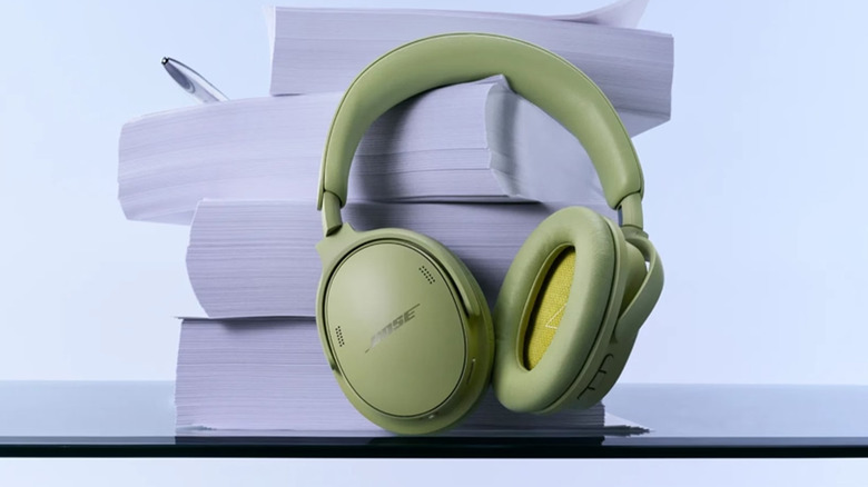 A Eucalyptus Green pair of Bose QuietComfort 2nd Gen headphones against a stack of papers.