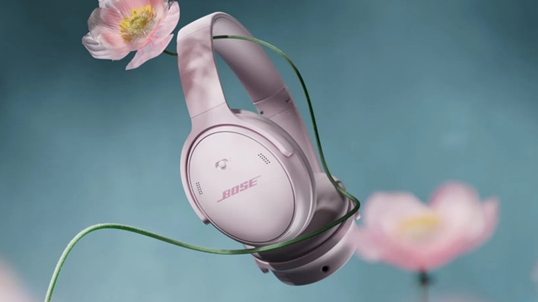 A pink pair of Bose QuietComfort 1st Gen headphones in a stylized image with a flower.