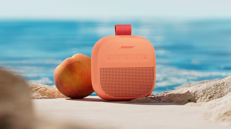 Peach color Bose speakers on a beach