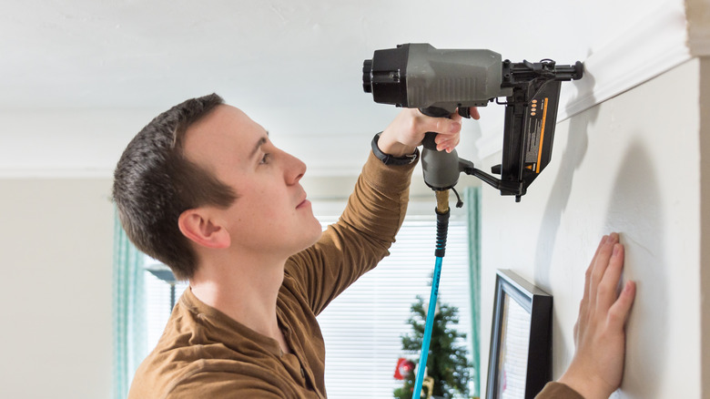 Man using finish nailer on moulding