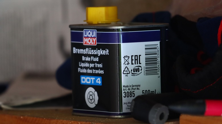 Container of brake fluid on shelf