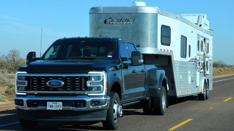 A pickup truck towing a fifth-wheel trailer on the highway