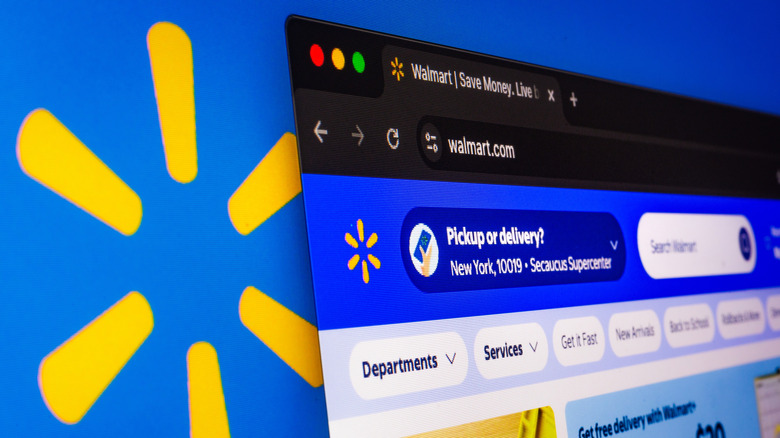 home page for Walmart online store on a computer screen in front of a large Walmart logo