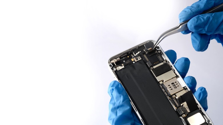 gloved hands removing SIM card