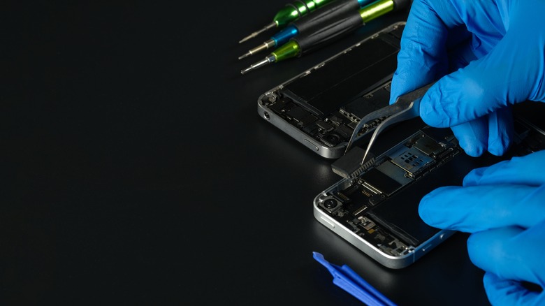 gloved hands repairing a smartphone