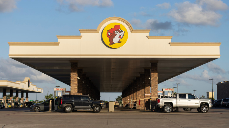 Side-on view of a Buc-ee's gas station court with several cars filling up
