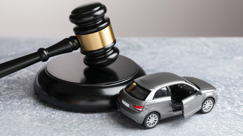 A gray model vehicle next to a judge's gavel.