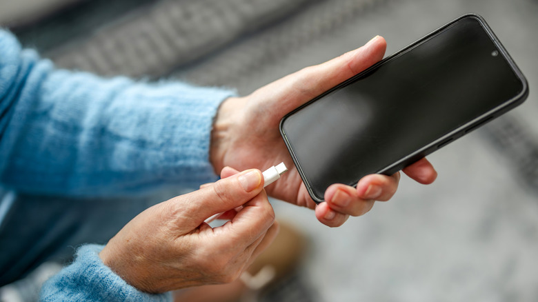A person plugging a Type-C charger into their phone