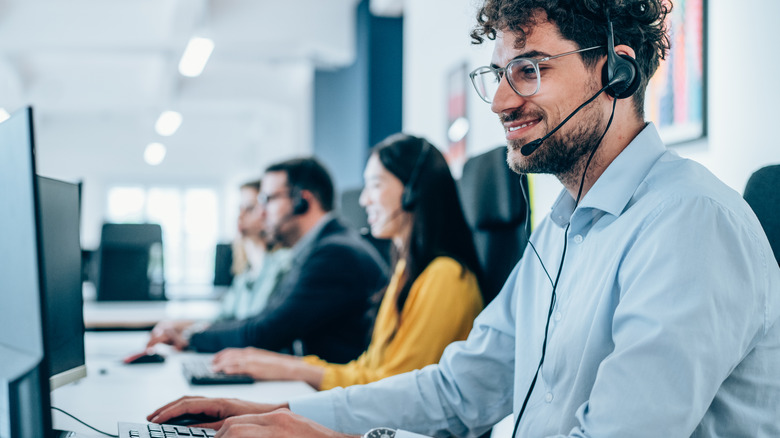 A row of customer care agents taking calls from customers